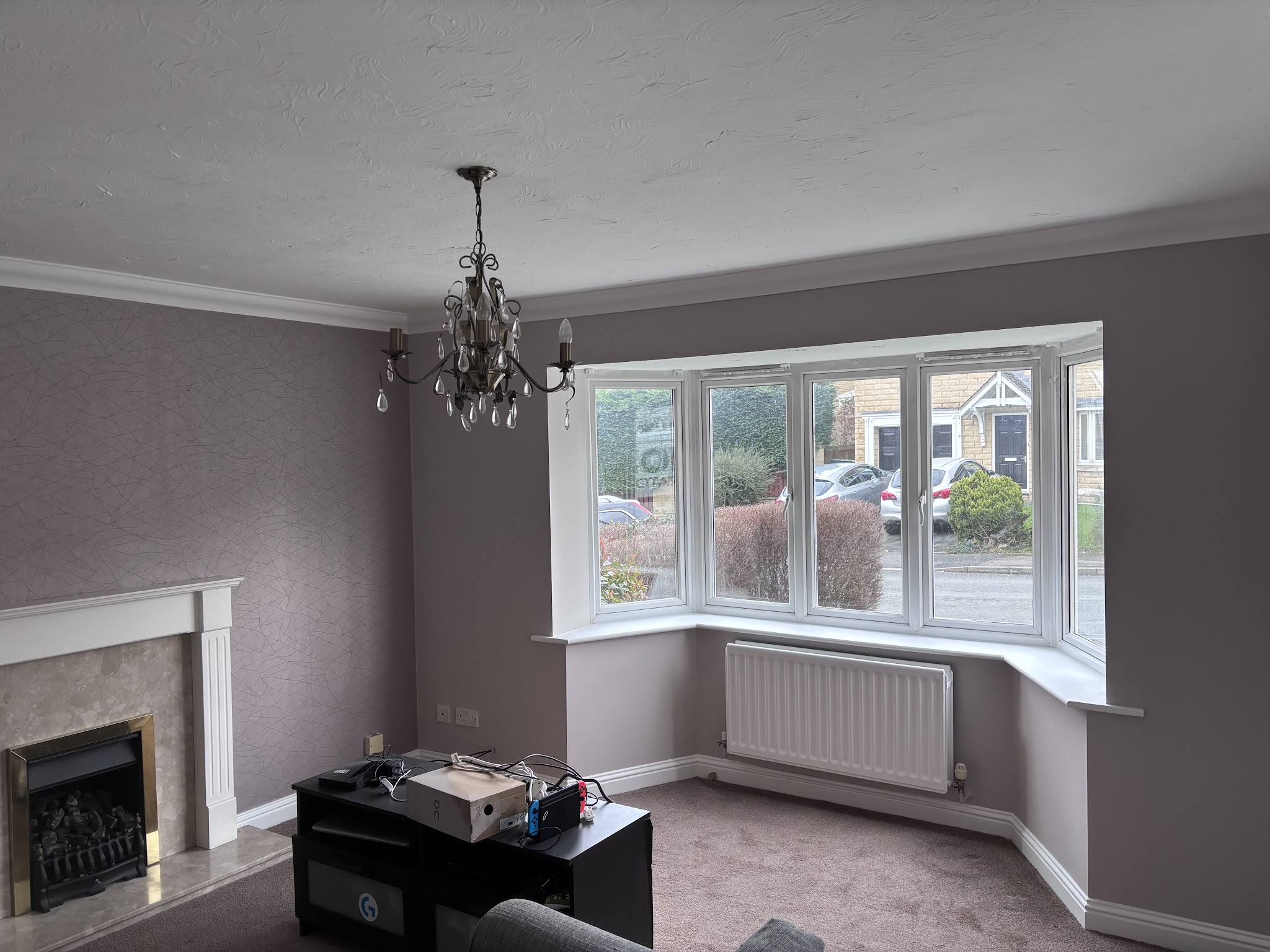 Decorated lounge with a patterned feature wall and freshly painted bay window